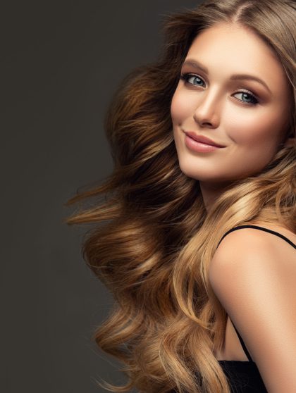 perfect-well-groomed-curly-long-deep-blonde-hair-is-surrounding-pretty-smiling-face-young-woman